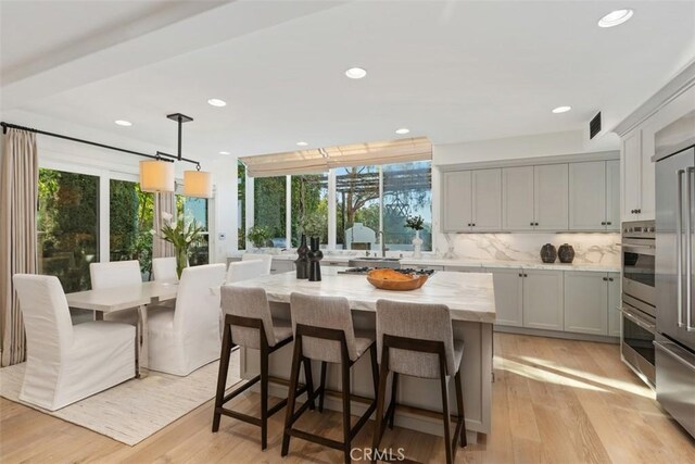35 Brindisi, Laguna Niguel, CA 92677 - kitchen featuring healthy amount of natural light, tasteful backsplash, light wood finished floors, light stone countertops, and recessed lighting