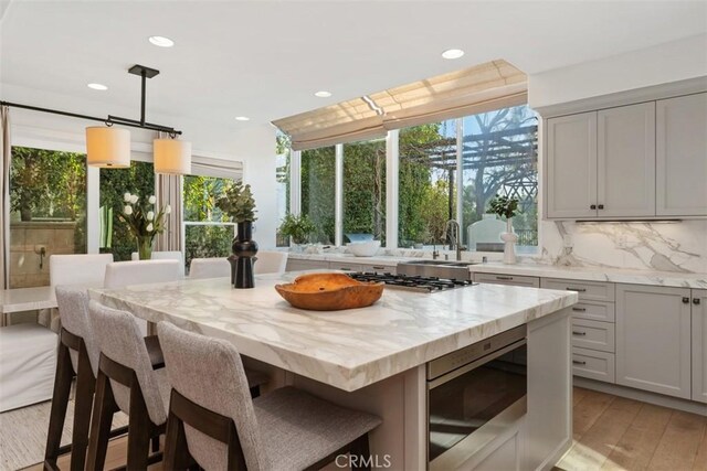 35 Brindisi, Laguna Niguel, CA 92677 - kitchen featuring appliances with stainless steel finishes, a breakfast bar area, light stone countertops, recessed lighting, and backsplash