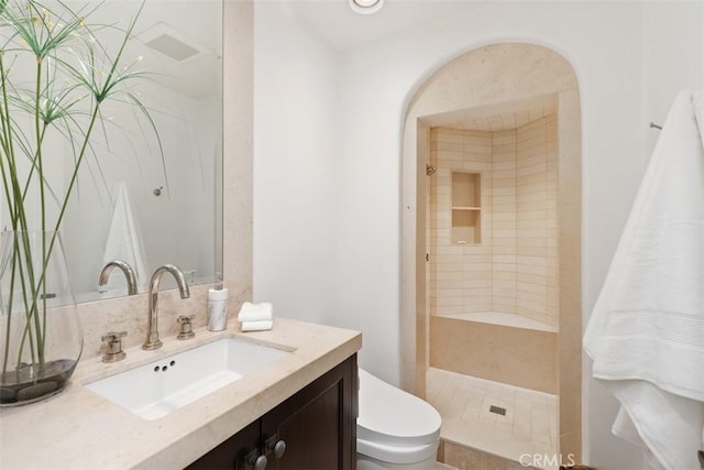 bathroom featuring a shower stall, toilet, and vanity