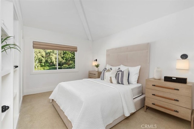 bedroom with baseboards, lofted ceiling, and light carpet