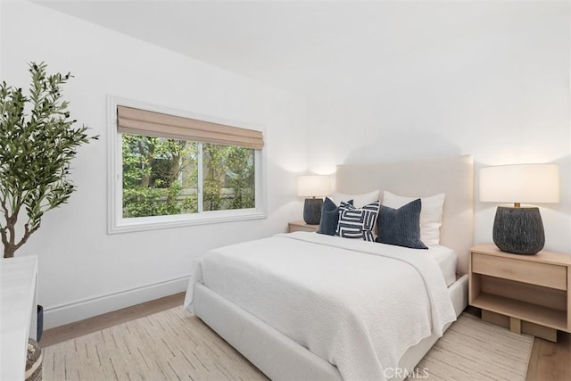 bedroom with baseboards and wood finished floors