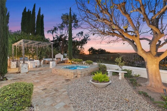 35 Brindisi, Laguna Niguel, CA 92677 - yard at dusk with an in-ground hot tub, a patio area, and an outdoor kitchen