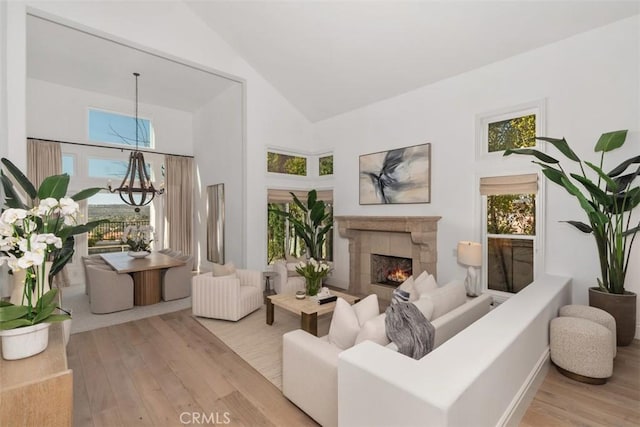 sitting room featuring high vaulted ceiling, a tile fireplace, and wood finished floors