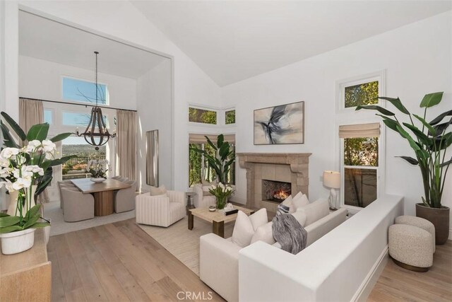 35 Brindisi, Laguna Niguel, CA 92677 - living room with high vaulted ceiling, a chandelier, wood finished floors, and a tile fireplace