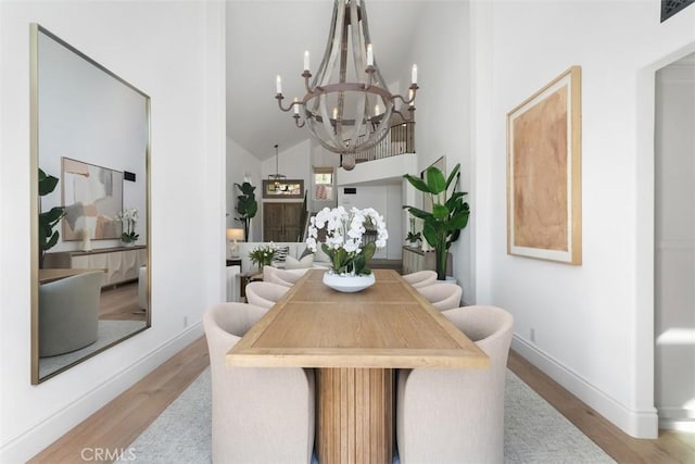 dining area featuring a notable chandelier, baseboards, and light wood-type flooring