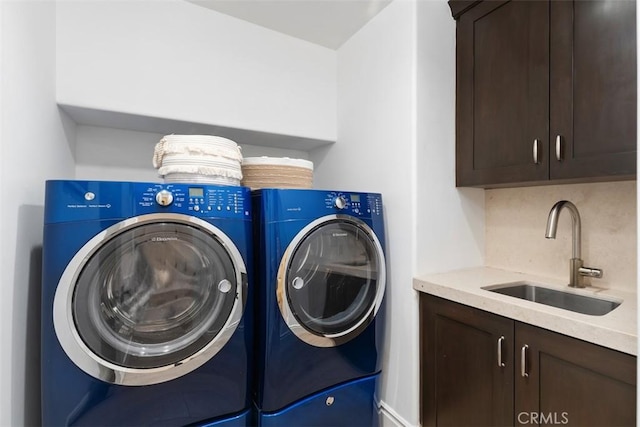 laundry room with a sink, cabinet space, and washer and dryer