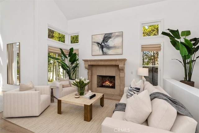 living area with plenty of natural light, a tile fireplace, and high vaulted ceiling