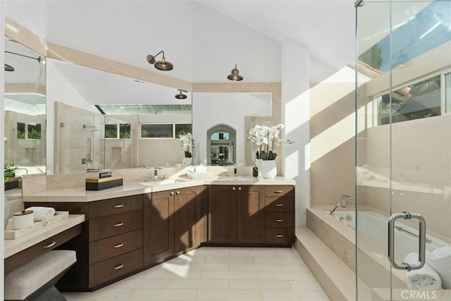 bathroom featuring double vanity, a stall shower, a sink, vaulted ceiling, and a garden tub