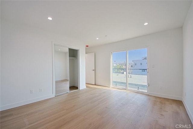 unfurnished bedroom featuring access to exterior and light hardwood / wood-style floors