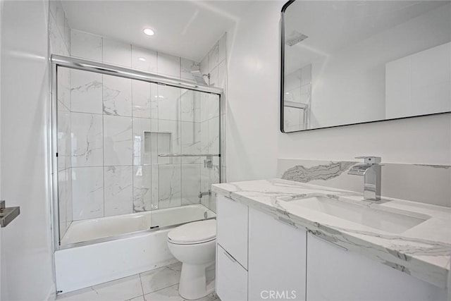 full bathroom with enclosed tub / shower combo, vanity, and toilet