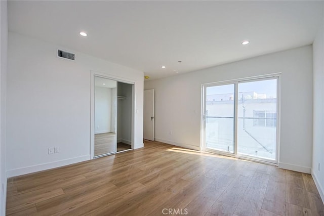 unfurnished bedroom featuring light hardwood / wood-style flooring and access to outside