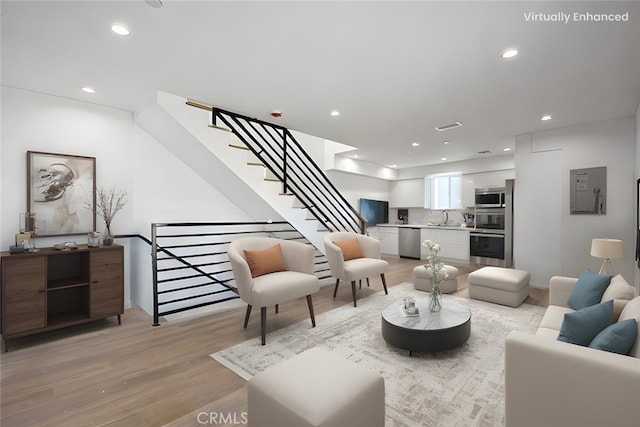 living room with sink and light wood-type flooring