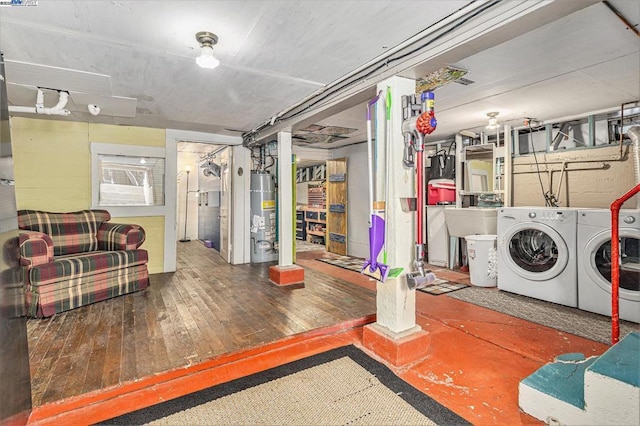 basement with washer and clothes dryer, hardwood / wood-style floors, and gas water heater