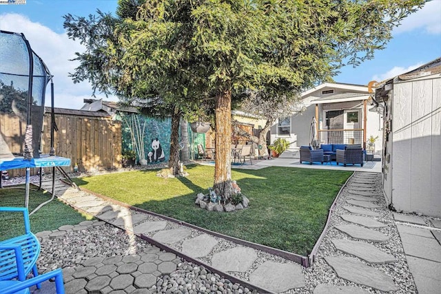 view of yard featuring a patio, outdoor lounge area, and a trampoline