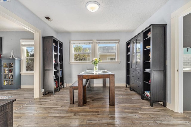 home office with wood-type flooring and a textured ceiling