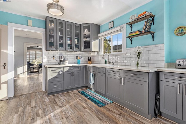 kitchen with gray cabinets, wood-type flooring, sink, and decorative backsplash