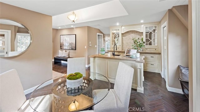 dining space with sink and dark parquet floors