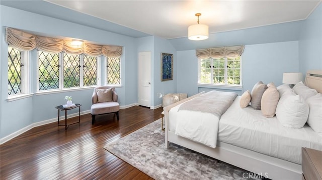 bedroom with multiple windows and dark hardwood / wood-style flooring