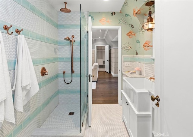 bathroom with sink, ornamental molding, and tiled shower