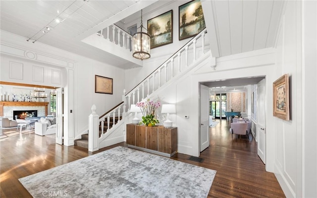 entryway with track lighting, dark hardwood / wood-style floors, and a notable chandelier