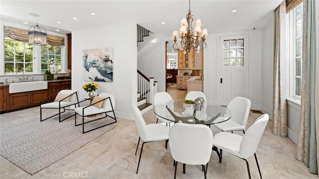 dining area featuring an inviting chandelier, sink, and a healthy amount of sunlight