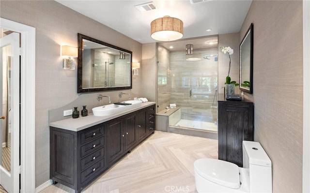 bathroom featuring toilet, parquet floors, vanity, and a shower with shower door