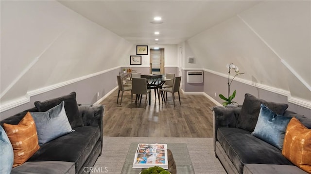 living room with a wall mounted air conditioner and hardwood / wood-style floors