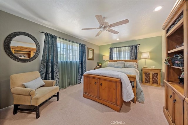 carpeted bedroom featuring multiple windows and ceiling fan