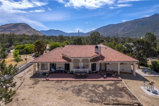 back of house featuring a mountain view and a patio area