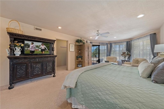 bedroom featuring light carpet, a textured ceiling, and ceiling fan