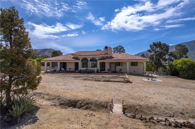 rear view of house with a mountain view and a patio