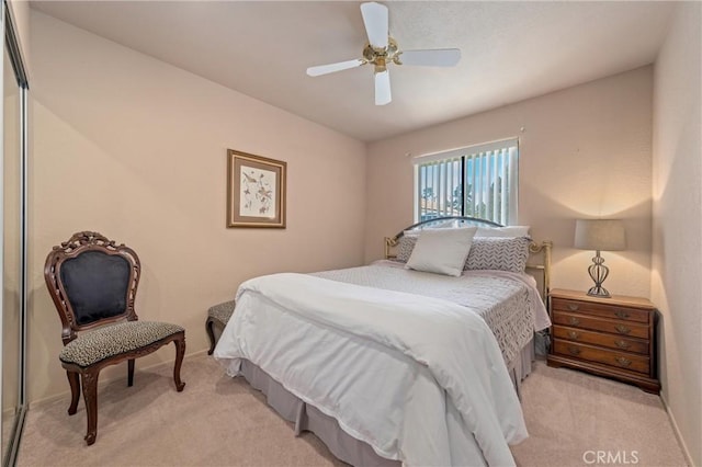 bedroom featuring ceiling fan, a closet, and light carpet