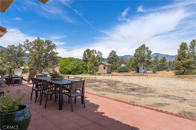 view of patio with a storage unit and a mountain view