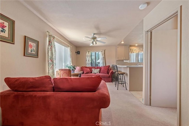 carpeted living room with ceiling fan