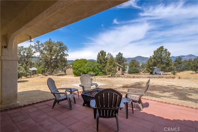 view of patio with a mountain view and a fire pit