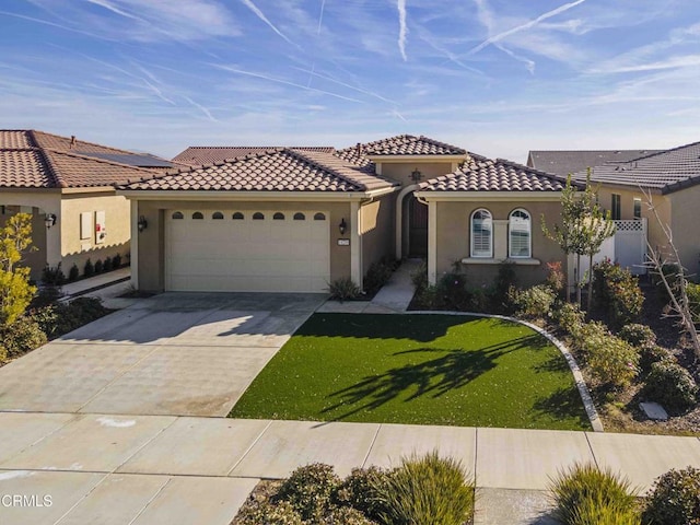 mediterranean / spanish house with a garage and a front lawn