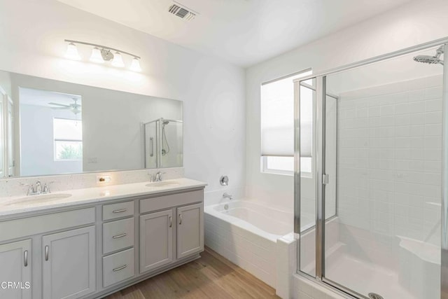 bathroom featuring ceiling fan, vanity, plus walk in shower, and hardwood / wood-style floors