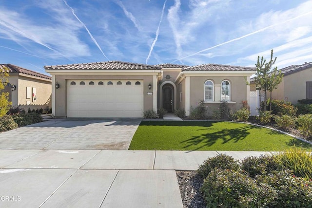 mediterranean / spanish house with a garage and a front yard