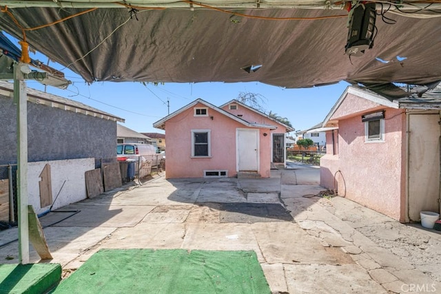 rear view of house with an outdoor structure and a patio area