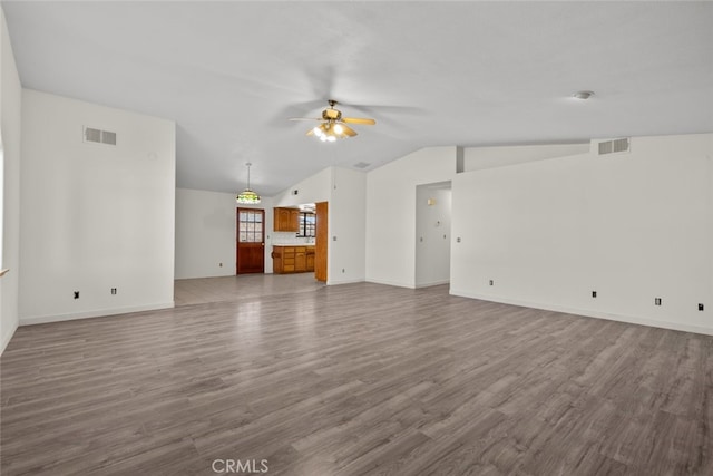 unfurnished living room featuring hardwood / wood-style flooring, ceiling fan, and vaulted ceiling