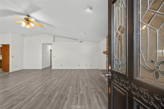 foyer featuring hardwood / wood-style flooring, vaulted ceiling, and ceiling fan