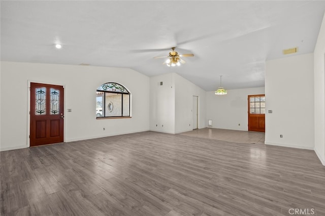 unfurnished living room featuring vaulted ceiling, a healthy amount of sunlight, ceiling fan, and light hardwood / wood-style floors