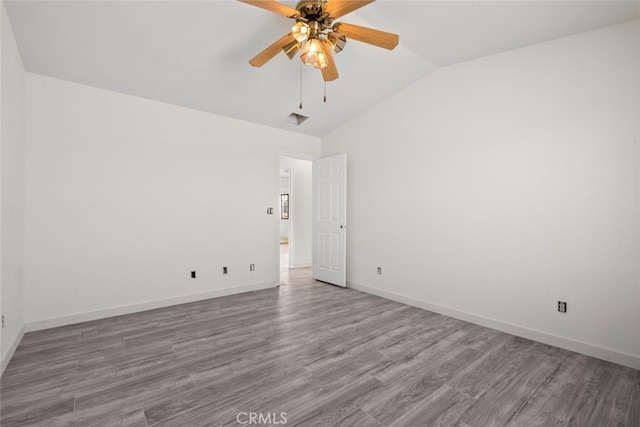 empty room featuring ceiling fan, wood-type flooring, and vaulted ceiling