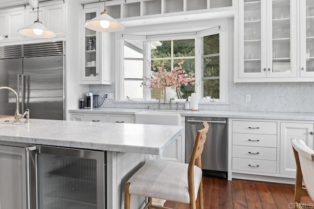 kitchen featuring glass insert cabinets, white cabinets, stainless steel appliances, beverage cooler, and a sink