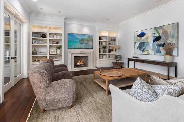 living area featuring recessed lighting, crown molding, built in shelves, hardwood / wood-style flooring, and a premium fireplace