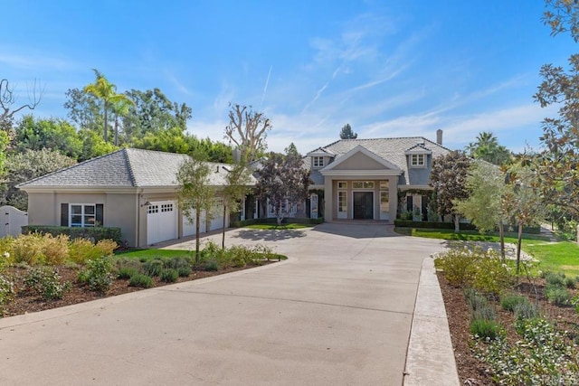 view of front facade with driveway, stucco siding, and an attached garage