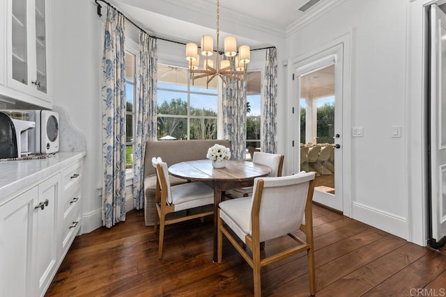 dining space featuring baseboards, a chandelier, dark wood-style floors, crown molding, and visible vents