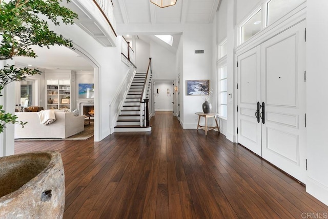 16625 Via Lago Azul, Rancho Santa Fe, CA 92067 - entryway with a lit fireplace, stairs, a high ceiling, dark wood-type flooring, and baseboards