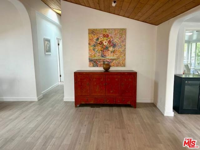 hallway featuring vaulted ceiling, light wood-type flooring, and wood ceiling