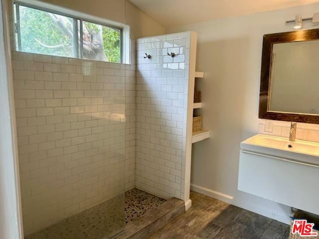 bathroom with vanity, hardwood / wood-style floors, and a tile shower